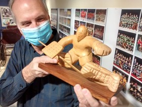 Mike Baker, Elgin County Museum curator, holds a carving of a hockey goalie by St. Thomas artist Frank Cvetich, loaned by Len Lynch for the current exhibit at the museum, Hockey. (Eric Bunnell, Special to Postmedia Network)