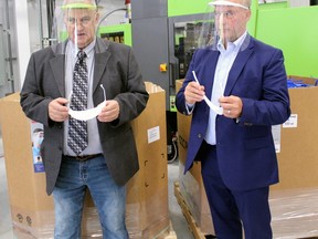 Donald Champagne, left, and Canadore College president George Burton check out some of the components of the ProtectON face shield being manufactured at Champagne's business, North Bay Plastic Molders in Corbeil, Friday. PJ Wilson/The Nugget