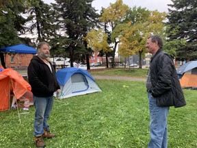 Shane Moyer talks to Mark King outside city hall Monday morning. King has assured Moyer that if he packs up his tent and belongings that suitable accommodations will be found for him and his friends. Moyer has been camping outside city hall since last Tuesday. He now has 10 friends living in tents beside him.