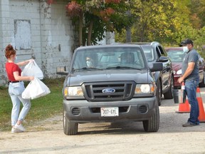 Customers receive their meals from Owen Sound Agricultural Society members at a drive thru beef barbecue at Victoria Park in Owen Sound on Saturday, September 26, 2020.