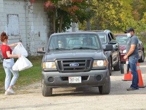 Customers receive their meals from Owen Sound Agricultural Society members at a drive thru beef barbecue at Victoria Park in Owen Sound on Saturday, September 26, 2020.