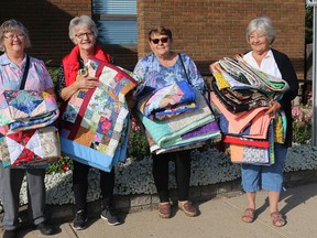 Arts N Craft Guild members Clara, Vi, Peggy, and Anne donating handmade quilts to the John A Smith Manor.