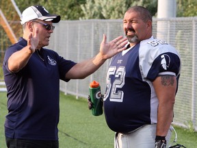 Sudbury Spartans defensive lineman Kevin White (52) talks with coach and former Spartans player Sam Cuomo during a break in Northern Football Conference action at James Jerome Sports Complex in Sudbury in 2015.