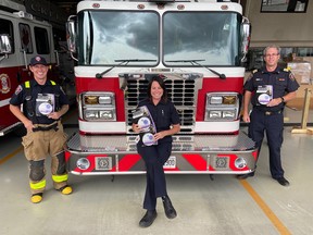 Firefighter Eric Smith (left), public educator Whitney Burk and assistant chief Ken Labonte of Chatham-Kent Fire & Emergency Services show the smoke and carbon monoxide alarms provided to homes through the Project Zero public education campaign. Handout