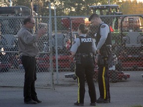 RCMP speak with a witness after a recent fire at Parkland Farm Equipment. Investigators have since labelled the fire non-suspicious.