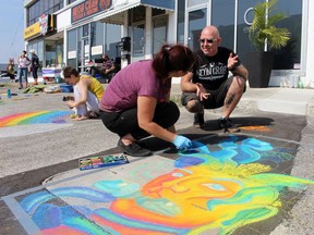 Will Graham talks to Sara Dunn as she participates in a street art competition in front of Graham's tattoo parlour on Sept. 26 in Sarnia. Dunn was declared one of the winners. Terry Bridge/Postmedia Network