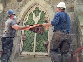 Stonemason Paul McLean, right, and helper Wayne Flood uncover a window which had been hidden from view for decades at Christ Church Anglican in Meaford, Ont. Friday, Sept. 18, 2020. (Scott Dunn/The Sun Times/Postmedia Network)