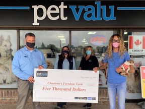 Adam Woodward, left, Amber Meyer and Kelly Van Bladel of Pet Valu present a $5,000 cheque to Lauren Edwards of Charlotte's Freedom Farm in August 2020 in Chatham, Ont., to help rebuild her farm animal rescue operation. (Contributed Photo)