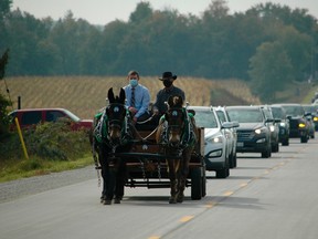 Procession for Jim Merriam on the way to the Tara Cemetery Thursday, Sept. 24, 2020. Grandson Sean Walsh and friend Durk DeVries drive the wagon pulled by Merriams's mules, Sly and Jenny. (Scott Dunn/The Sun Times/Postmedia Network)