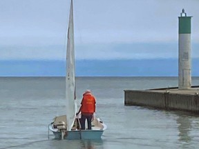 Reginald Fisher of Dutton, who vanished Thursday after his small sailboat capsized on Lake Erie, is seen on the 14-foot craft in the Port Glasgow harbour earlier this month in an image taken by a restaurant worker there. Police say the 77-year-old, the search for whom was called off Monday, was not an experienced sailor. Supplied photo/The London Free Press/Postmedia Network