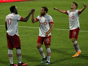 Toronto FC forward Jozy Altidore (17) celebrates his goal against Montreal Impact with teammates Nick DeLeon (18) and Marco Delgado (8) during action at Stade Saputo in Montreal, Sept. 9, 2020.