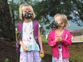 Children settled in back at school last week with masks, hand sanitizer stations, and friendly reminders from teachers to stay apart from your friends at all times. (Left-right) Zola Burks and Tess looks up to her big sister starting kindergarten at Elizabeth Rummel School in Canmore on September 2. Photo Marie Conboy.