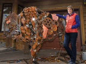 Metal sculptor Cedar Mueller with a buffalo she is in the process of creating with various pieces of metal. photo by Pam Doyle/www.pamdoylephoto.com
