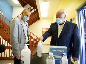 Premier Doug Ford, right, uses hand sanitizer as he gets a tour of Kensington Community School from principal Dan Fisher to see the safety measures implemented as students return to school amidst the COVID-19 pandemic on Tuesday. THE CANADIAN PRESS