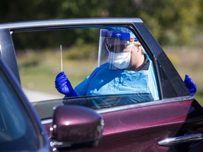 A paramedic holds a testing swab at a pop-up testing centre Saturday in Ottawa. The two-day blitz involved paramedics from Hastings-Quinte Paramedic Services and eight other services.