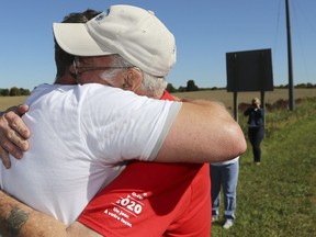 Wally Sawkins, right, hugs his son, Jeff, after Jeff completed a 24-km run Sunday to retrace the route they took with Terry Fox into Madoc, Ont. "I'm overwhelmed," said Wally, who is fighting cancer for the second time.
