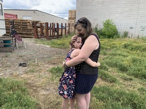 Brenda Wilson, a niece of Mary Hammond, embraces her daughter, Charlee, at the spot in Brantford where Hammond when missing on Sept. 8, 1983. Wilson, accompanied by husband Jef, and son Dustin visited the location in July during a trip to southern Ontario. The family lives in Almonte, Ont. Vincent Ball