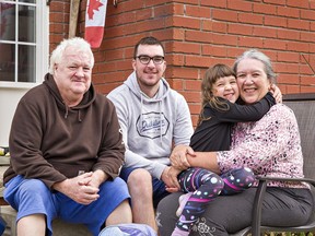 Five-year-old Layla Adams gives her grandmother Karen Cameron a hug after returning home from the first day of school on Tuesday in Brantford, Ontario. With her are her grandfather Gordon Cameron and her uncle Kevin Cameron.