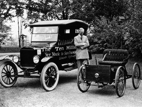 Henry Ford stands between the 10 millionth Model T and his first car, the Quadricycle.