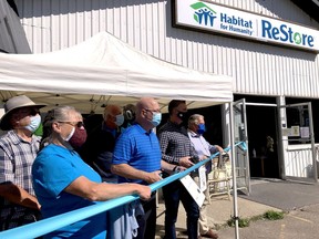 Debbie Cozens, front left, a volunteer at Habitat for Humanity, joins Leeds-Grenville-Thousand Islands and Rideau Lakes MPP Steve Clark, MP Michael Barrett and Elizabethtown-Kitley Mayor Brant Burrow at the ribbon-cutting for the Habitat ReStore's expansion on Saturday morning. Seen behind are board member Dave Standen, left, and vice-chairman Martin Van Andel. (RONALD ZAJAC/The Recorder and Times)