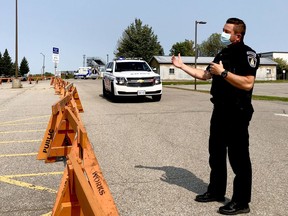 Brockville police special constable Jonathan Zinck speaks to a driver in the Memorial Centre parking lot on Wednesday afternoon. Police were sending away potetial users of the COVID-19 assessment centre after the facility was booked for the day, with many left waiting in their cars. (RONALD ZAJAC/The Recorder and Times)