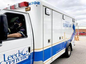 Paramedic Peter Joseph sits in an ambulance blocking the entrance to Brockville's COVID-19 assessment centre on Thursday afternoon to indicate the lineup has already reached capacity. (RONALD ZAJAC/The Recorder and Times)