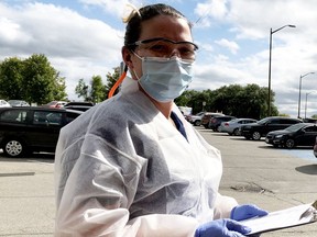 Paramedic Kali Burnham prepares to do more patient intake in the parking lot of Brockville's COVID-19 assessment centre in September. (FILE PHOTO)