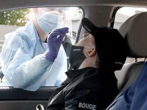 Preston Bougie, 11, of Carleton Place, gets his nose swabbed by paramedic Jessica Foran to test for COVID-19 on Friday morning, one of many regional residents who drove into the Leeds and Grenville paramedics' pop-up testing centre at Centre 76 in Athens. (RONALD ZAJAC/The Recorder and Times)