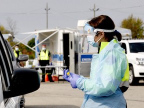 Leeds and Grenville paramedic Katie Huntley prepares to administer a nasal swab in the parking lot of Centre 76 last Friday morning, as people pack a pop-up COVID-19 testing site run by the counties' paramedic service. (FILE PHOTO)