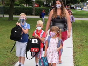 Andrea Taylor has some trepidation about her children, Harrison, 7, front left, and five-year-old twins Donavan and Raelynn going to school during  pandemic. They are seen here arriving at Tecumseh Public School in Chatham, Ont. on Thursday September 10, 2020. Ellwood Shreve/Chatham Daily News/Postmedia Network