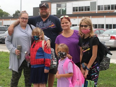 Many families had worries as their children returned to school on Thursday, including Jennifer Geroux and partner Bill Balkwill, back left, with their child Lily Balkwill, front left, and Stacey Gore and her two children Danica, back right, and Braelyn. Ellwood Shreve/Chatham Daily News/Postmedia Network