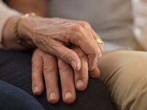 An elderly couple holding hands.