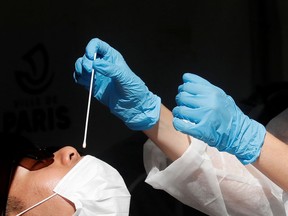 A health worker prepares to administer a nasal swab to a patient at a testing site for the coronavirus disease (COVID-19).