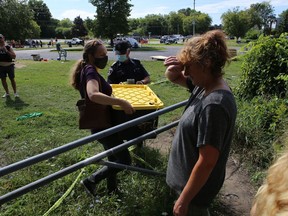 Homeless advocates carry out belongings of Belle Park residents as the city closed down the encampment in Kingston on Tuesday. (Elliot Ferguson/The Whig-Standard)