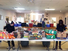 Morningstar Mission volunteers Hope Rose and Holly Carlyle, front, and Morningstar executive director Kevin Alkenbrack sort donated food from Lionhearts Inc. on Saturday at the Napanee Lions Hall. The food will go towards creating 1,000 meals for people in need across Lennox and Addington County. (Meghan Balogh/The Whig-Standard)