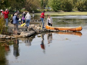 Volunteers prepare to launch an Algonquin birch bark canoe into the waters of the Cataraqui River for the first time on Saturday. The canoe was built as a project by Friends of Kingston Inner Harbour, powered by volunteers and guided by Chuck Commanda, an Algonquin knowledge-keeper. (Meghan Balogh/The Whig-Standard)