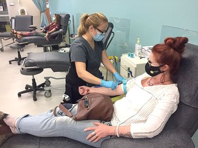Rebecca Pidgeon, a donor care assistant at the Canadian Blood Services clinic on Gardiner's Road in Kingston, prepares to receive a blood donation from Jennifer Allan on Sept. 17, 2020.