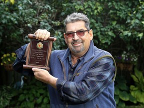 Retired Correctional Service Canada officer Michael Pickett on Wednesday with an award he received for a life-saving rescue of an inmate who attempted to hang himself on Christmas Day 1989. (Ian MacAlpine/The Whig-Standard)