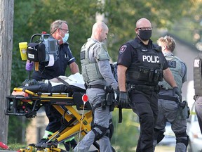 Police and paramedics remove a man from a home on Ford Street after Kingston Police responded to a scene  after a man allegedly stabbed three people and barricaded himself in the home on Wednesday September 23, 2020.