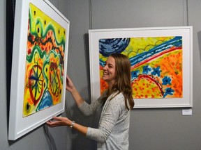 Evan Schonfeldt from the Museum of Northern History is all smiles as she sets up an exhibition from local artist Lionel Venne.
