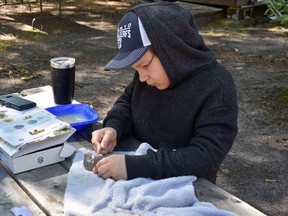 Hard at work to carve his sculpture in soapstone is 11 year old Moses Meaniss, Beaverhouse FN Youth.