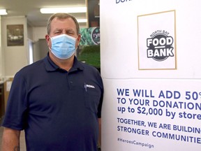 Lakeview Rona manager Al McCauley stands beside a banner promoting the Lowe's Canada 2020 Heroes campaign. The store, as well as Rona Lakeview Builders Supplies, is collecting donations all September for the North Bay Food Bank. Michael Lee/The Nugget