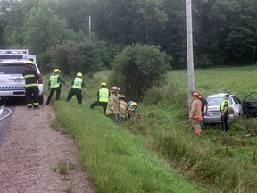 The driver of the silver car on the right, involved in a single vehicle crash on Beachburg Road on Wednesday afternoon, Sept. 2, is assisted from her vehicle and up the ditch towards a waiting paramedic vehicle. Anthony Dixon