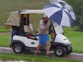 Bruce Hanna, runner-up for the Don Watson Trophy at the 58th Annual Earl Grey Golf Tournament in Petawawa, seeks shelter from the heavy rains on Sunday afternoon at the event which eventually led to it being halted. Submitted photo
