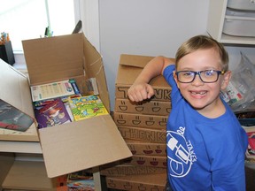 Seven-year-old Jake Rooney, likely Pembroke's youngest entrepreneur, is surrounded by an incoming shipment of books and an outgoing stack of his subscription boxes. He is the 'boss' of Jake's Crates, a subscription box service. Anthony Dixon