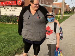 Celine Gaudreau waits with son Simon at a bus stop near Lambton Central Collegiate and Vocational School on Monday September 14, 2020 in Petrolia, Ont. Terry Bridge/Sarnia Observer/Postmedia Network