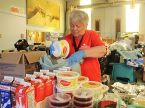 Volunteer Lynn Davidson packs food at the Inn of the Good Shepherd on Thursday June 11, 2020 in Sarnia, Ont. An annual Loonies for Lunches fundraising campaign is underway to help stock shelves with school snacks. (Paul Morden/Sarnia Observer)