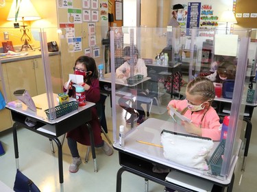 Joni McDonnell, left, and Molly Dodge participate in a school activity behind a plexiglass shield at MacLeod Public School in Sudbury, Ont. on Tuesday September 8, 2020. John Lappa/Sudbury Star/Postmedia Network