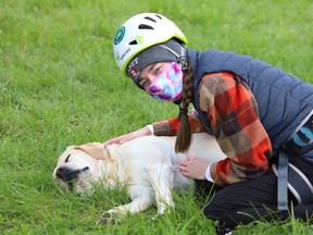 Laurentian University student Maggie Ryan visits with Cedar the dog during an outdoor class in Sudbury, Ont. on Friday September 18, 2020.