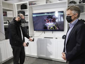Former Ontario Finance Minister Rod Phillips, right, looks on as Andrew Kostwik, studio manager of NORCAT, demonstrates the Vale VR during a tour of NORCAT in Sudbury, Ont. on Friday September 18, 2020. John Lappa/Sudbury Star/Postmedia Network